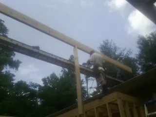 Carpenter setting a ridge beam over a new addition frame — Ice Dam Removal by Roofing Brothers in Bloomdale