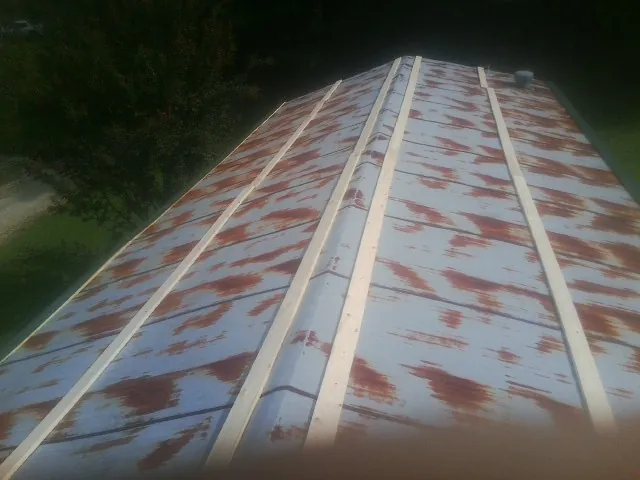 Rusted metal roof panels with new wood purlins before replacement — Storm Damage Roof Repair in Bloomdale by Roofing Brothers