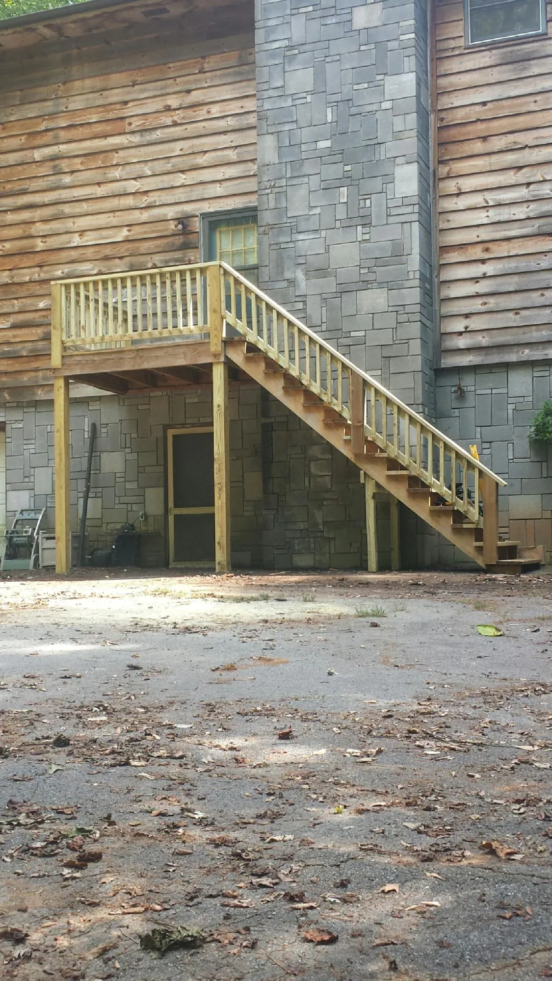 New pressure treated deck and stair landing on a log home in Bloomdale