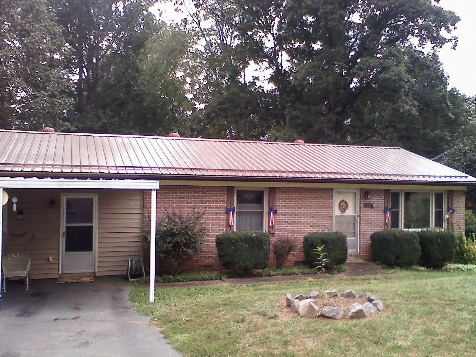 Bronze metal roof and carport on a brick ranch home — Roof Repair work by our crew in Bloomdale